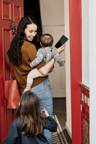 A picture of a family entering a home.