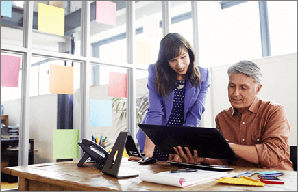 Photograph of two people working on a tablet computer.