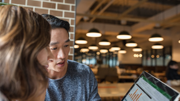 Couple in cafe looking at Excel chart