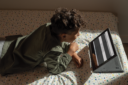 A middle school boy reads a webpage with Immersive Reader in Microsoft Edge.