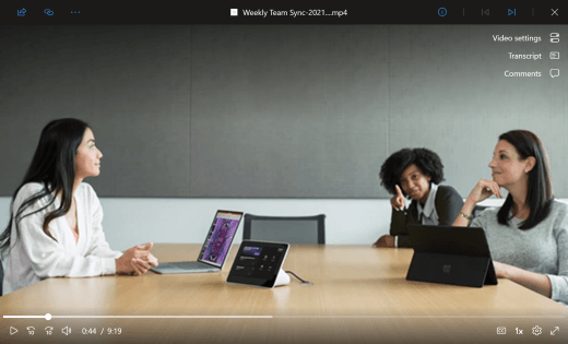 Un lecteur vidéo montre une réunion Teams en cours. Trois employés de bureau s’assoient autour d’une table de conférence avec des appareils en face d’eux. L’interface utilisateur à l’écran en haut à droite montre aux utilisateurs où ils peuvent accéder aux paramètres vidéo pour activer et désactiver les sous-titres et les commentaires.