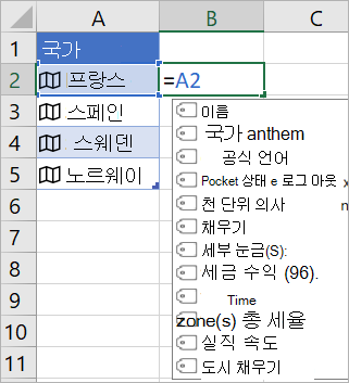 A2 셀에는 “프랑스”가 포함되어 있으며, B2 셀에는 =A2.이 포함되어 있고 연결된 레코드의 필드와 함께 수식 자동 완성 메뉴가 나타납니다.