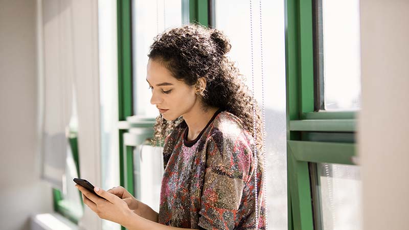 Bilde av en kvinne som holder en telefon.