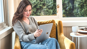 Uma mulher segurando um dispositivo Surface