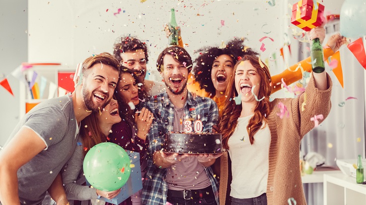 Fotografia de um grupo de amigos a celebrar com comida, bebidas e confetis.