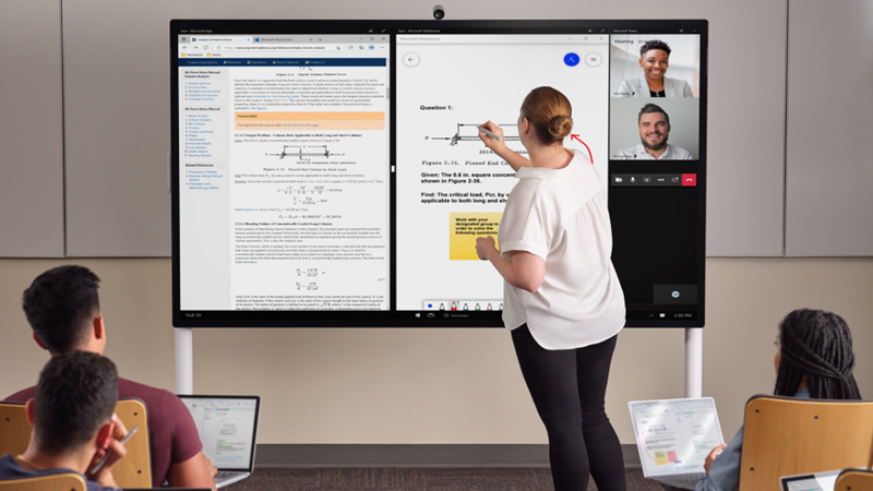 Učiteľ je v prednej časti triedy písania rukou na Hub 85", s svetlosivým perom pre Surface. Edge Whiteboard a Teams sú na obrazovke. V popredí má viacero študentov verziu Pro 7+ a zaznamenávajú si poznámky v jednej poznámke.