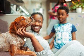 En leende familj med sin hund