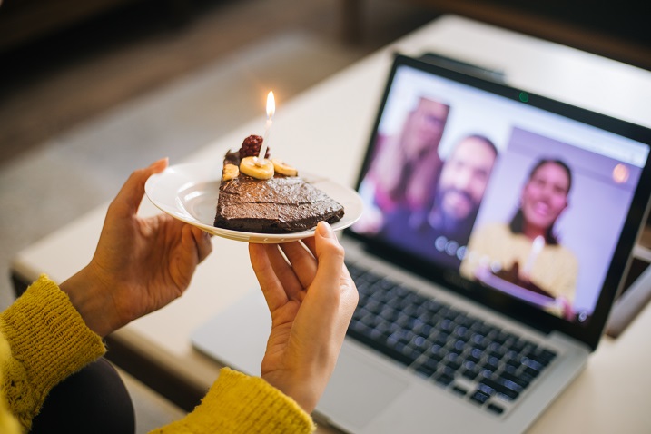 web kamerasının önünde kek resmi tutan bir kişinin fotoğrafı